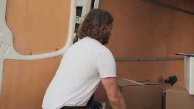 Önlüklü sarışın bir kafe çalışanı arabadan teslimat yapıyor.