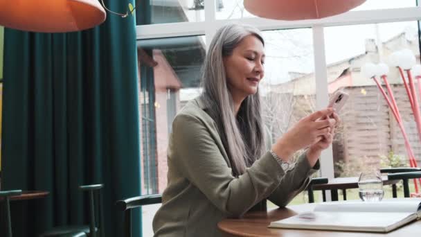 Nöjd Kvinna Använder Sin Smartphone Sitter Caféet Inuti — Stockvideo