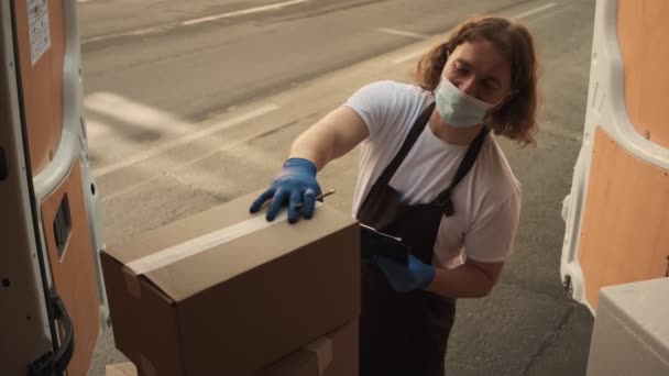 Ein Mann Mit Medizinischer Schutzmaske Und Handschuhen Nimmt Die Lieferung — Stockvideo
