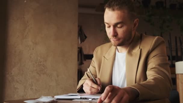 Серйозний Білий Бізнесмен Який Працює Квитанцією Сидячи Столом Кафе — стокове відео