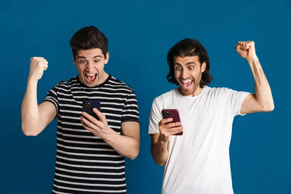 Возбудили Двух Мужчин Сделавших Жест Победителя Используя Мобильные Телефоны Изолированные — стоковое фото