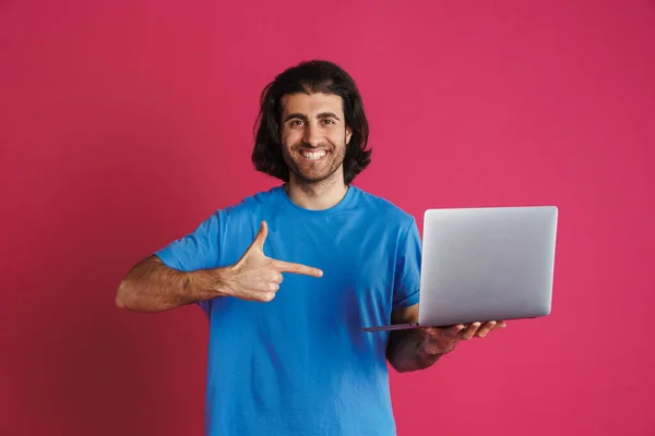 Nieogolony Uśmiechnięty Mężczyzna Trzymający Wskazujący Palcem Laptop Odizolowany Różowym Tle — Zdjęcie stockowe