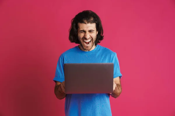 Unshaven Homem Animado Gritando Segurando Laptop Isolado Sobre Fundo Rosa — Fotografia de Stock