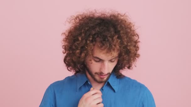 Een Nerveuze Krullende Man Voelt Warm Staande Geïsoleerd Roze Achtergrond — Stockvideo