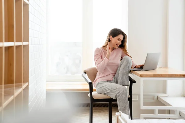Lounge Giysileri Giyen Mutlu Beyaz Kadın Masada Dizüstü Bilgisayarla Oturuyor — Stok fotoğraf