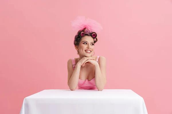 Mujer Joven Con Rulos Sonriendo Cámara Mientras Está Sentada Mesa —  Fotos de Stock