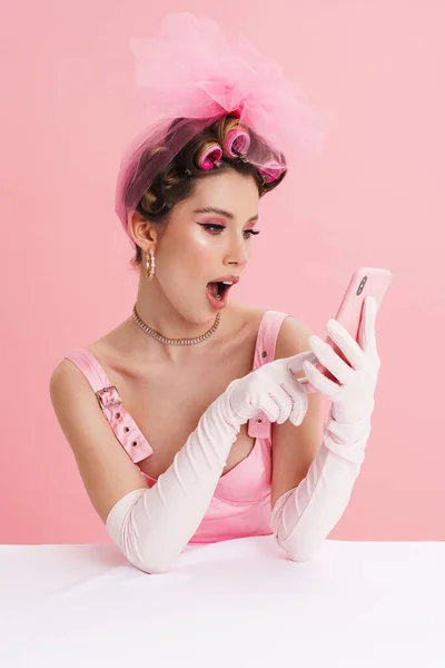 Jovem Sorridente Mulher Branca Barbie Vestido Rosa Sentado Mesa Isolado — Fotografia de Stock