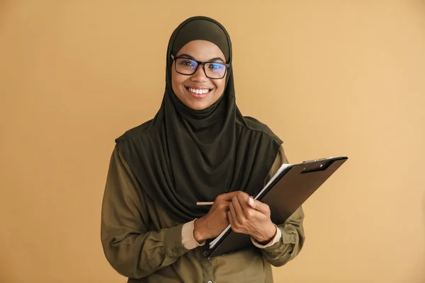 Schwarze Muslimische Frau Mit Brille Schreibt Notizen Auf Klemmbrett Isoliert — Stockfoto