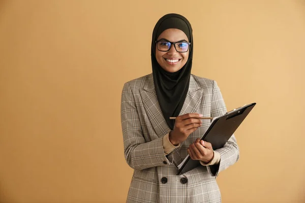 Černá Muslimka Žena Brýlích Psaní Poznámek Schránce Izolované Přes Béžové — Stock fotografie