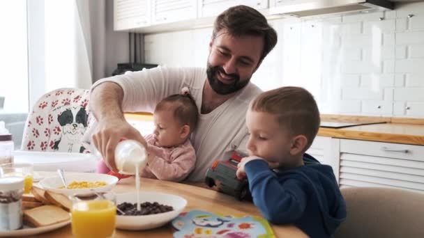 Ein Zufriedener Vater Frühstückt Mit Seinen Zwei Kleinen Kindern — Stockvideo