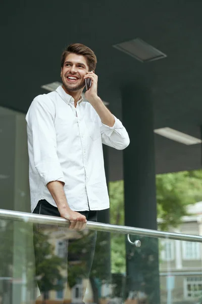 Zadowoleni Europejscy Biznesmeni Rozmawiający Przez Telefon Komórkowy Szukający Czegoś Młody — Zdjęcie stockowe