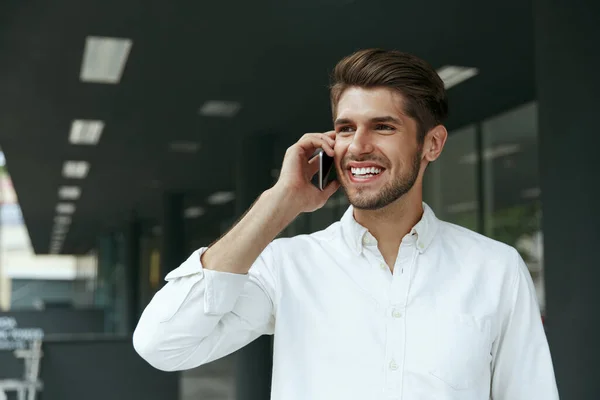 Homem Negócios Europeu Agradável Falando Telefone Celular Jovem Fundo Moderno — Fotografia de Stock