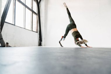 Protezli genç sporcu kadın içeride çalışırken egzersiz yapıyor.