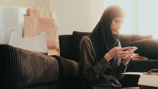 Una Donna Araba Concentrata Sta Usando Suo Smartphone Mentre Disfa — Video Stock