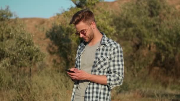 Ein Junger Mann Mit Sonnenbrille Benutzt Sein Smartphone Wenn Sommer — Stockvideo