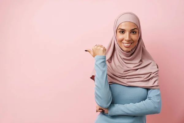 Eine Lächelnde Muslimin Pinkfarbenen Hijab Zeigt Auf Den Kopierraum Rosa — Stockfoto