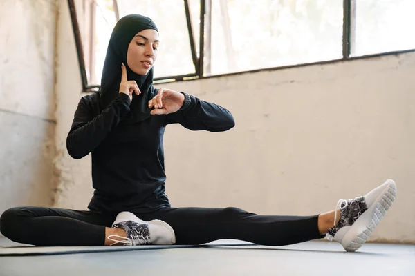 Młoda Muzułmanka Hidżabie Mierzy Puls Podczas Treningu Pomieszczeniu — Zdjęcie stockowe