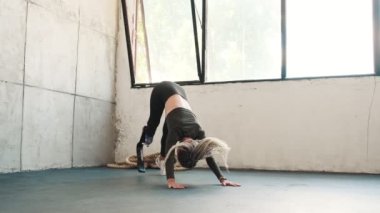 Bacak protezi olan güzel bir kadın stüdyoda yoga egzersizleri yapıyor.