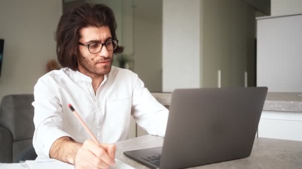 一位穿着白衬衫和眼镜的土耳其男子震惊地在屋里的笔记本电脑上写下了一些东西 — 图库视频影像