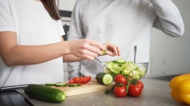 Mutlu bir çiftin yakın plan görüntüsü kadın ve erkek salata pişiriyor.