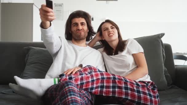 Ett Lyckligt Par Kvinna Och Man Väljer Kanaler Sitter Soffan — Stockvideo