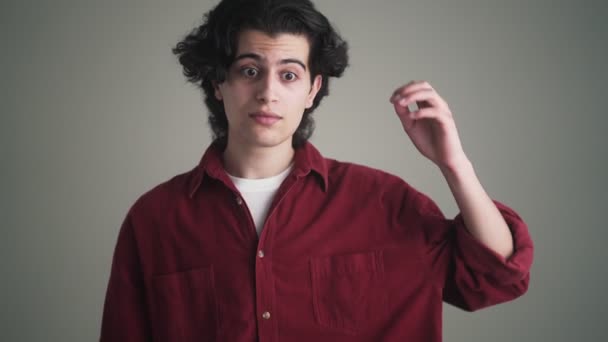 Hombre Moreno Confuso Con Una Camisa Roja Encoge Hombros Pie — Vídeos de Stock