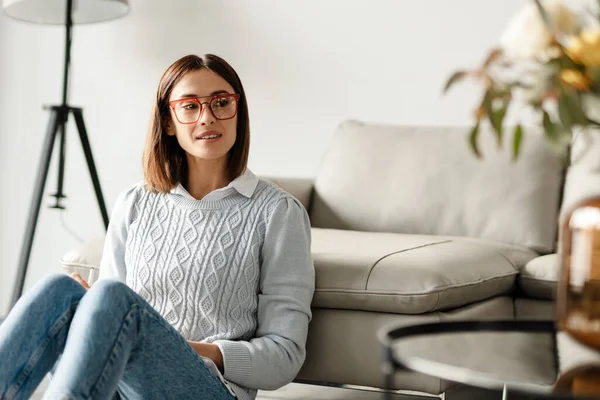 Mujer Mediana Edad Sonriente Suéter Sentado Sofá Con Gafas Interior — Foto de Stock