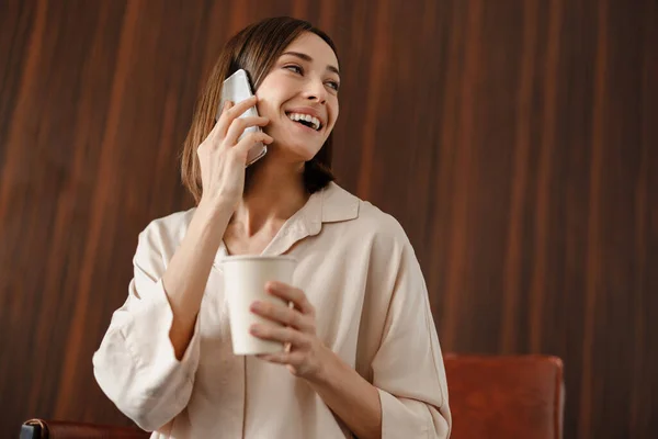 Lächelnde Frau Trinkt Kaffee Und Telefoniert Sessel Drinnen — Stockfoto