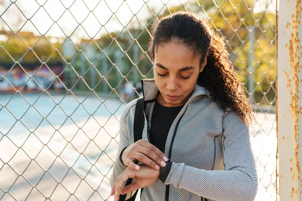 Focused African American Sportswoman Using Smartwatch While Standing Outdoors — 스톡 사진