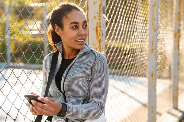 Joyful African American Sportswoman Using Mobile Phone While Standing Outdoors — 스톡 사진