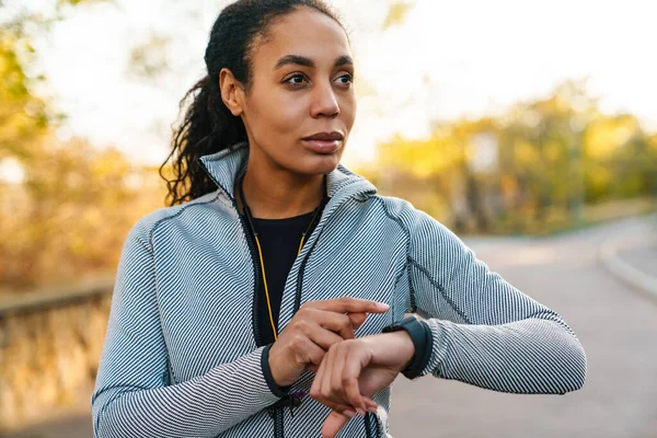 Focused African American Sportswoman Using Smartwatch While Working Out Park — 스톡 사진