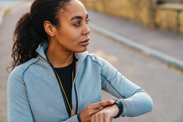 Focused African American Sportswoman Using Smartwatch While Working Out Park — 스톡 사진