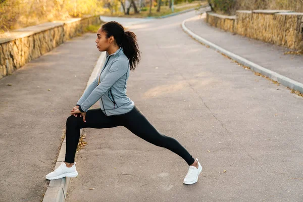 Konzentrierte Afrikanisch Amerikanische Sportlerin Streckt Ihre Beine Beim Training Park — Stockfoto