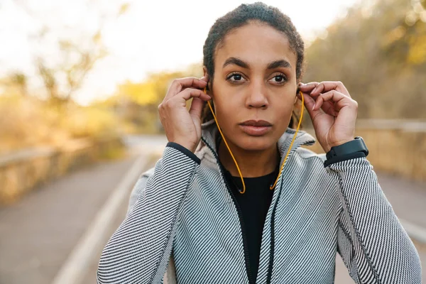 Beautiful African American Sportswoman Using Earphones While Working Out Park — 스톡 사진