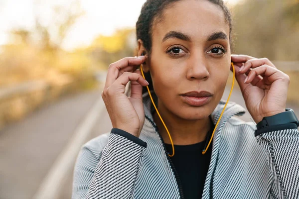 Beautiful African American Sportswoman Using Earphones While Working Out Park — 스톡 사진