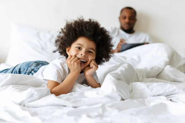 Schwarzer Junge Lacht Während Sein Vater Hause Tablet Computer Bett — Stockfoto