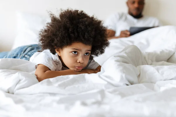 Schwarzer Junge Runzelt Die Stirn Während Sein Vater Hause Tablet — Stockfoto