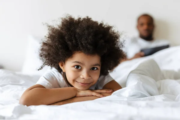 Schwarzer Junge Lächelt Während Sein Vater Hause Tablet Computer Bett — Stockfoto