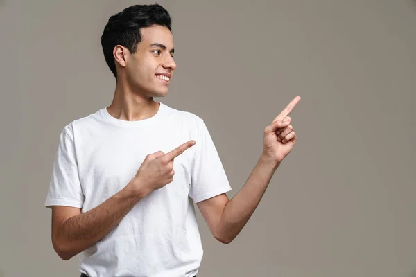 Brunette Spaanse Man Shirt Glimlachend Wijzend Vinger Opzij Geïsoleerd Grijze — Stockfoto