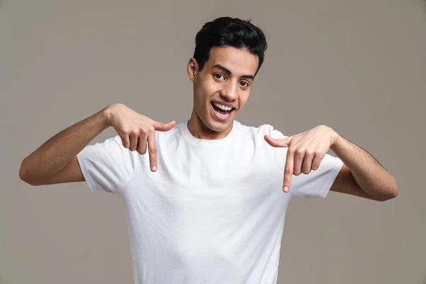 Sorrindo Jovem Morena Homem Shirt Sobre Fundo Parede Cinza Apontando — Fotografia de Stock