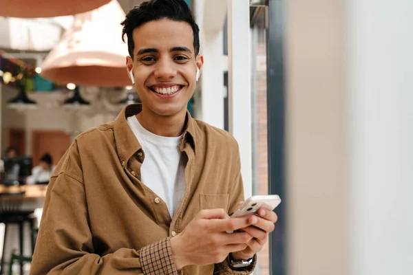 Leende Ung Latinamerikan Hörlurar Videosamtal Mobiltelefon Stående Caféet Inomhus — Stockfoto