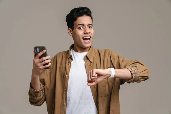 Brunett Hispanic Man Skriker När Använder Mobiltelefon Och Smartwatch Isolerad — Stockfoto