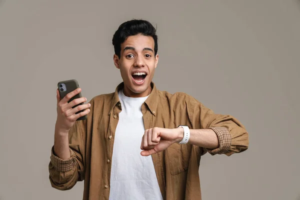 Spännande Latinamerikansk Man Skriker När Använder Mobiltelefon Och Smartwatch Isolerade — Stockfoto