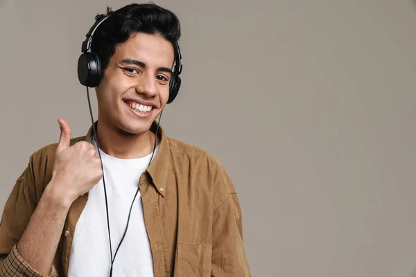 Hispanic Man Visar Tummen Upp Medan Lyssnar Musik Med Hörlurar — Stockfoto
