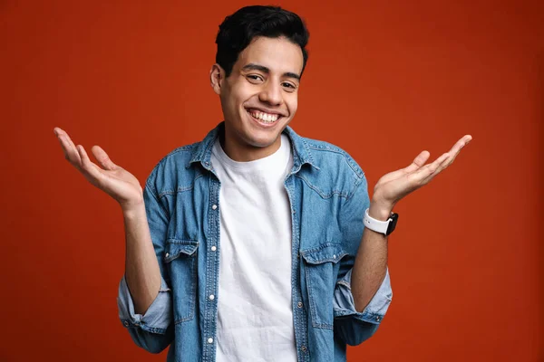 Brunette Hispanic Man Shirt Gebaren Glimlachen Camera Geïsoleerd Rode Achtergrond — Stockfoto