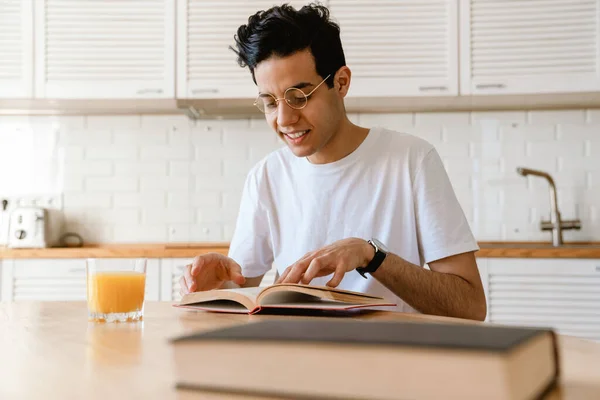 Giovane Uomo Ispanico Sorridente Che Legge Libro Mentre Colazione Cucina — Foto Stock