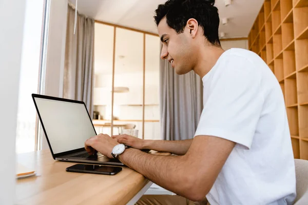 Lächelnder Junger Hispanischer Mann Arbeitet Laptop Während Hause Schreibtisch Sitzt — Stockfoto