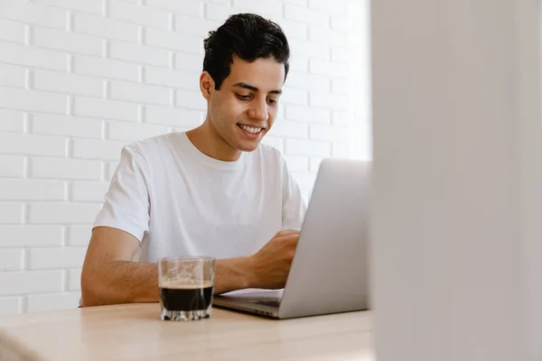 Sorrindo Jovem Hispânico Que Trabalha Estudando Computador Portátil Enquanto Está — Fotografia de Stock