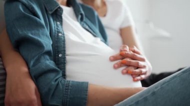 Mutlu bir Igbt kadınının yakın planda çekilmiş bir görüntüsü hamile kadın sevgilisine sarılıyor.