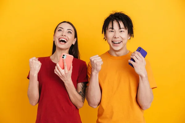 Jovem Casal Multirracial Fazendo Gesto Vencedor Usar Telefones Celulares Isolados — Fotografia de Stock